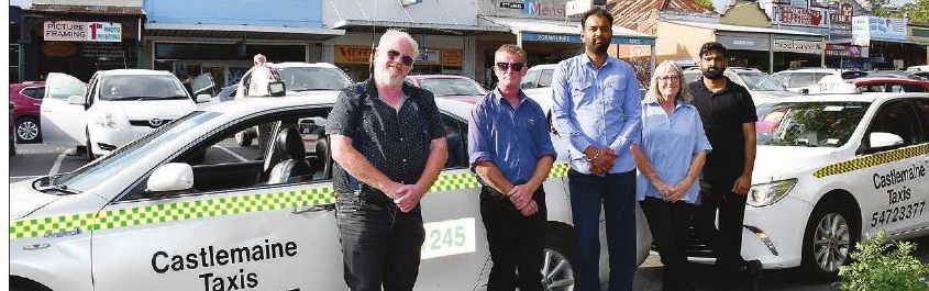 Castlemaine Taxis drivers lined up beside their two cars.